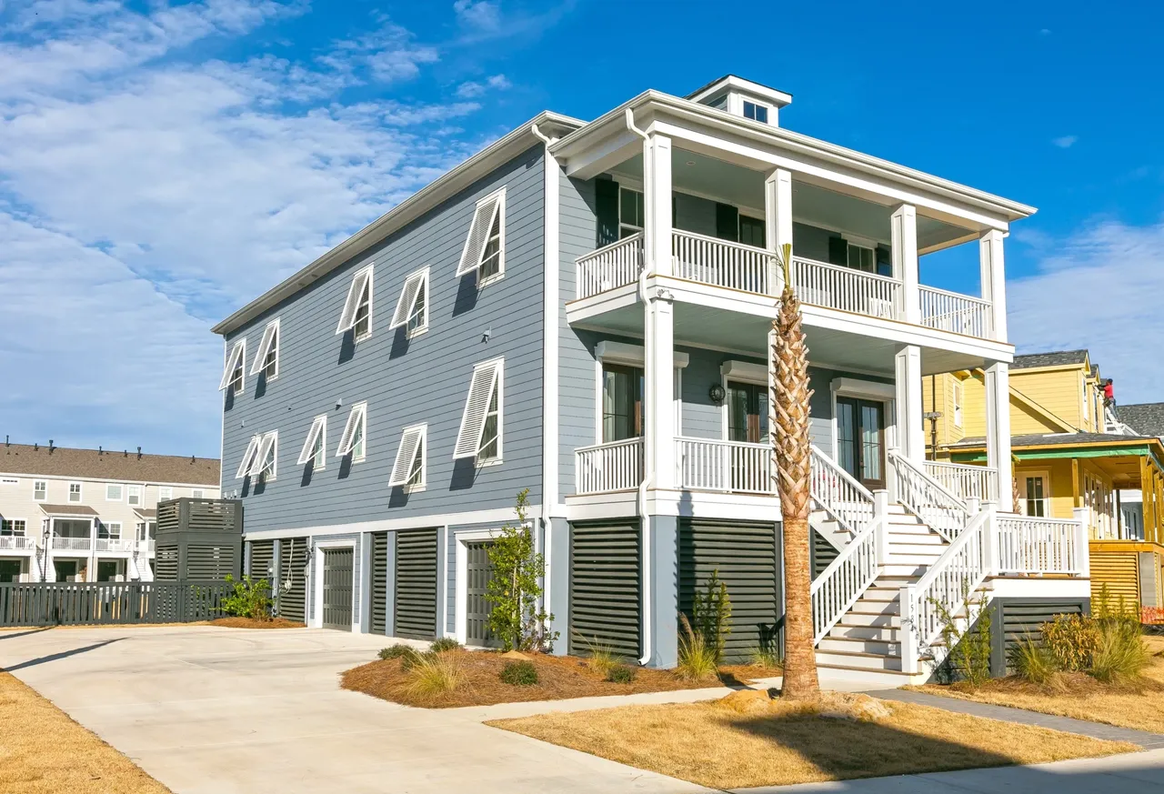 Large coastal beach house with white balconies and blue-gray siding