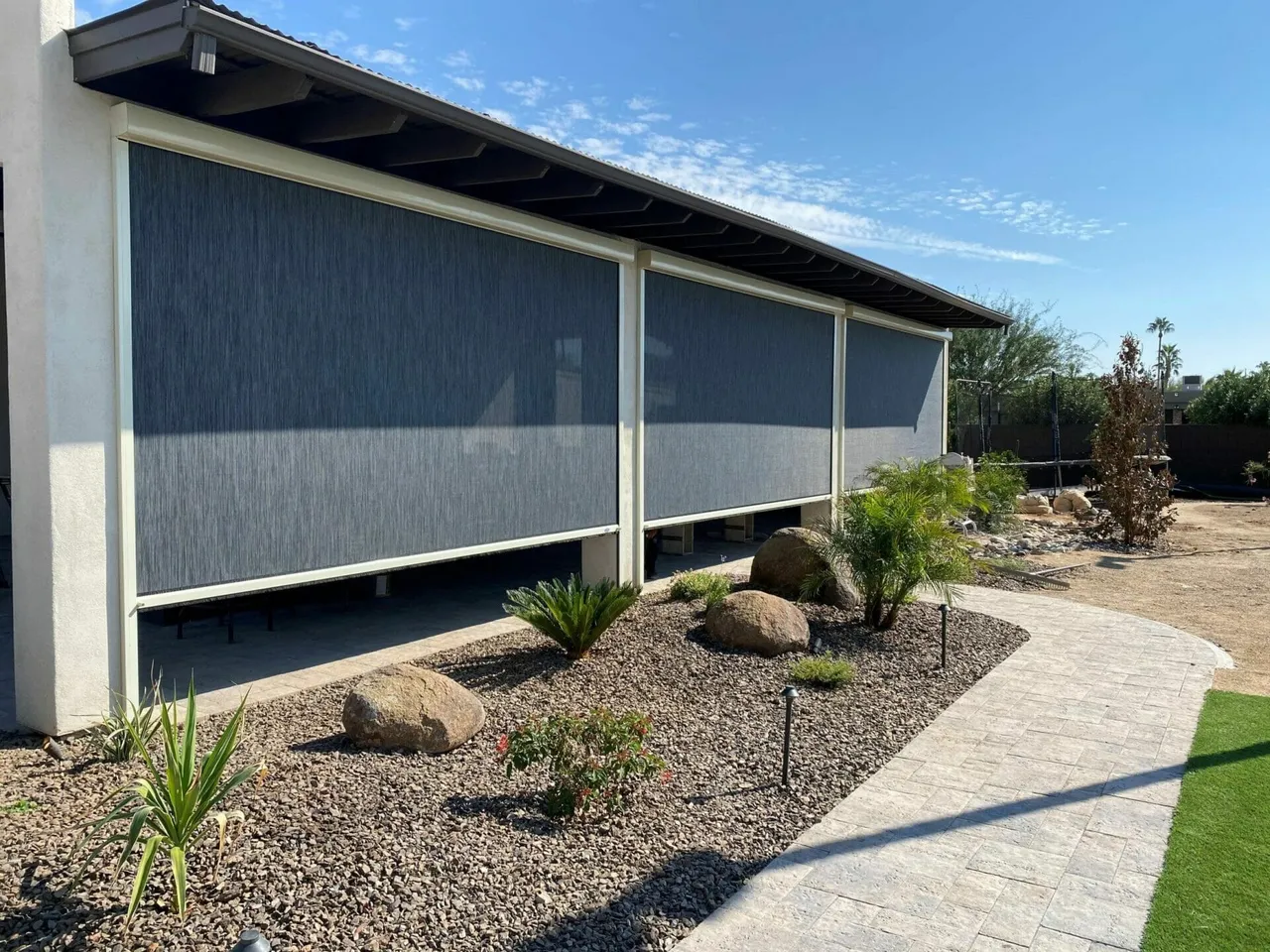 Modern patio with retractable screens, rocks, and desert landscaping